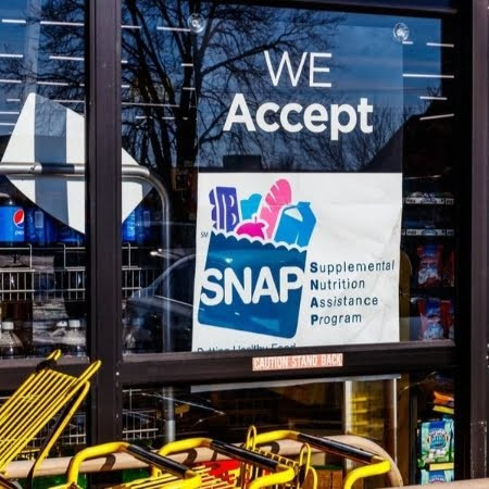 A SNAP card and fresh produce, representing the use of SNAP benefits for healthy food.