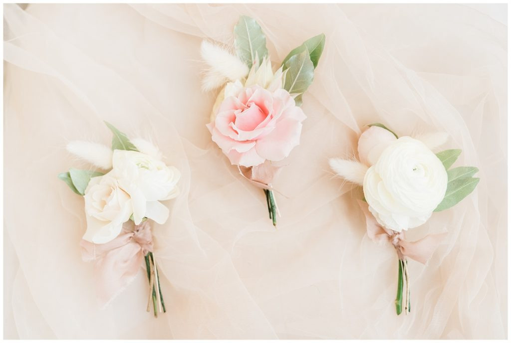 Pink and cream boutonnieres styled beautifully for the Red Bank Teak wedding.