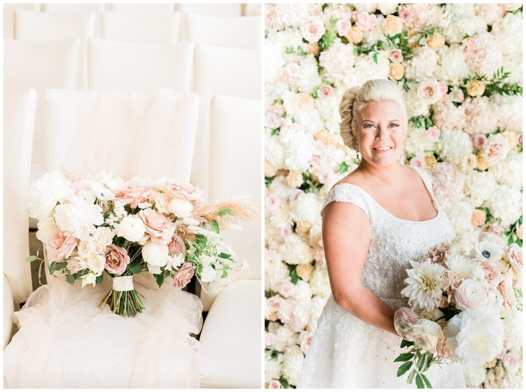 Bride posing with her bouquet in front of the flower wall at Teak Red Bank wedding venue.