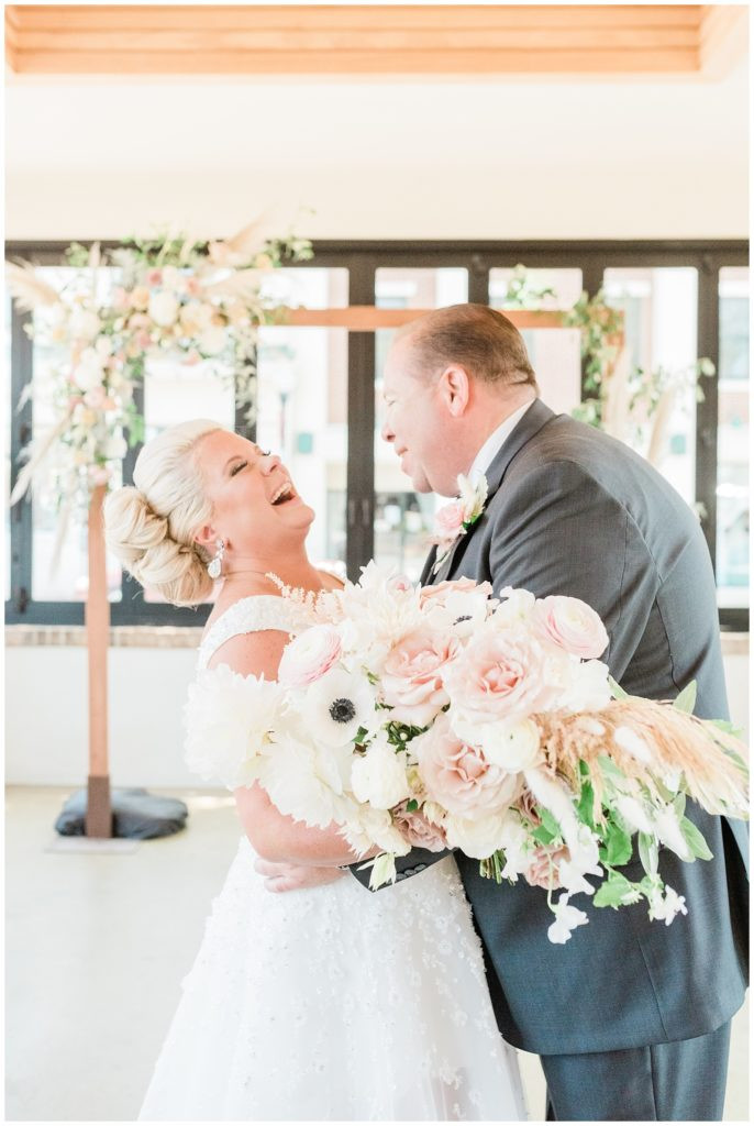 Bride and groom sharing a laugh during their wedding ceremony at Teak in Red Bank.