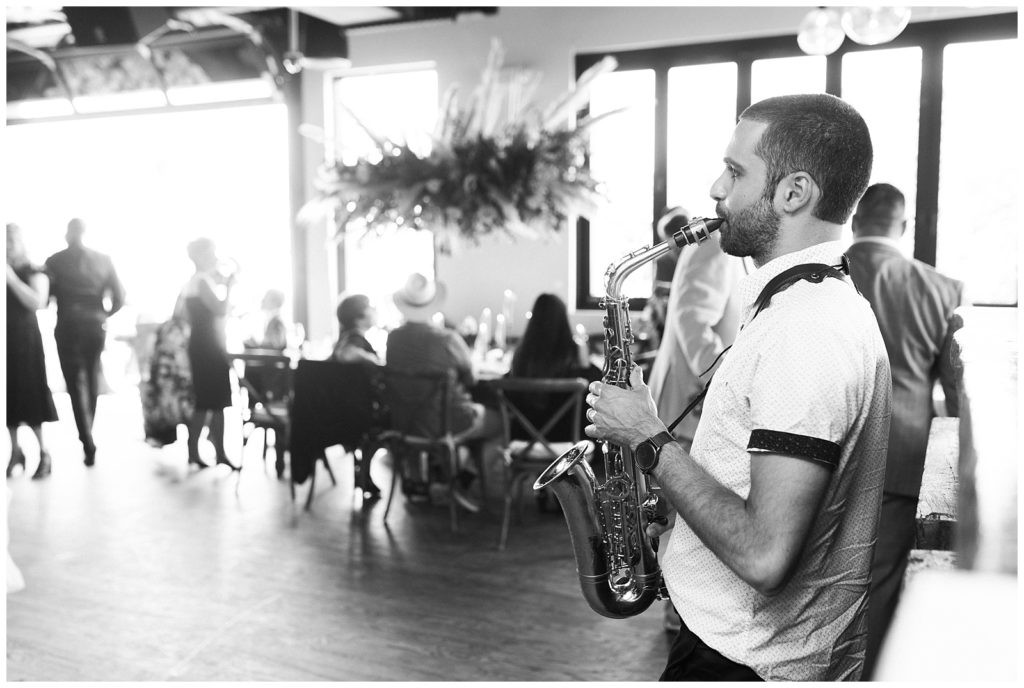 Musician playing saxophone during cocktail hour at Teak Red Bank wedding reception.