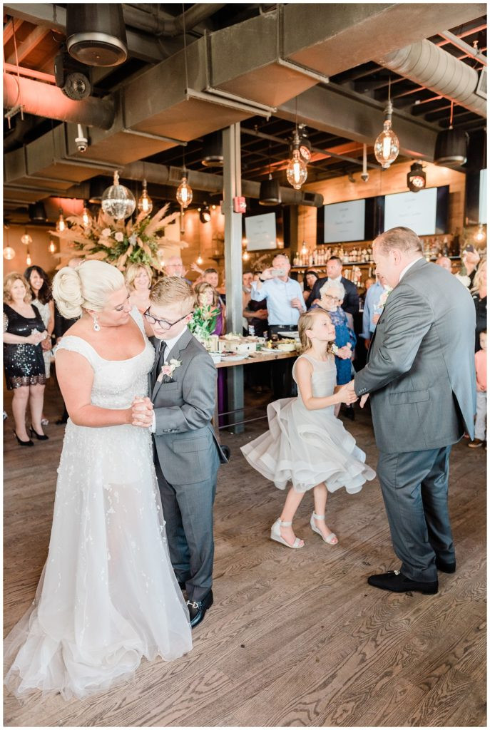 Bride and groom dancing with their children in a family first dance at Teak Red Bank.