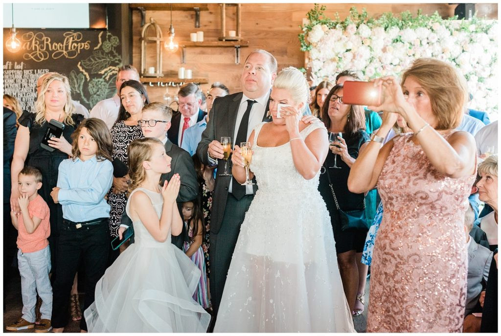 Bride wiping a tear while listening to emotional toasts at Teak Red Bank wedding.