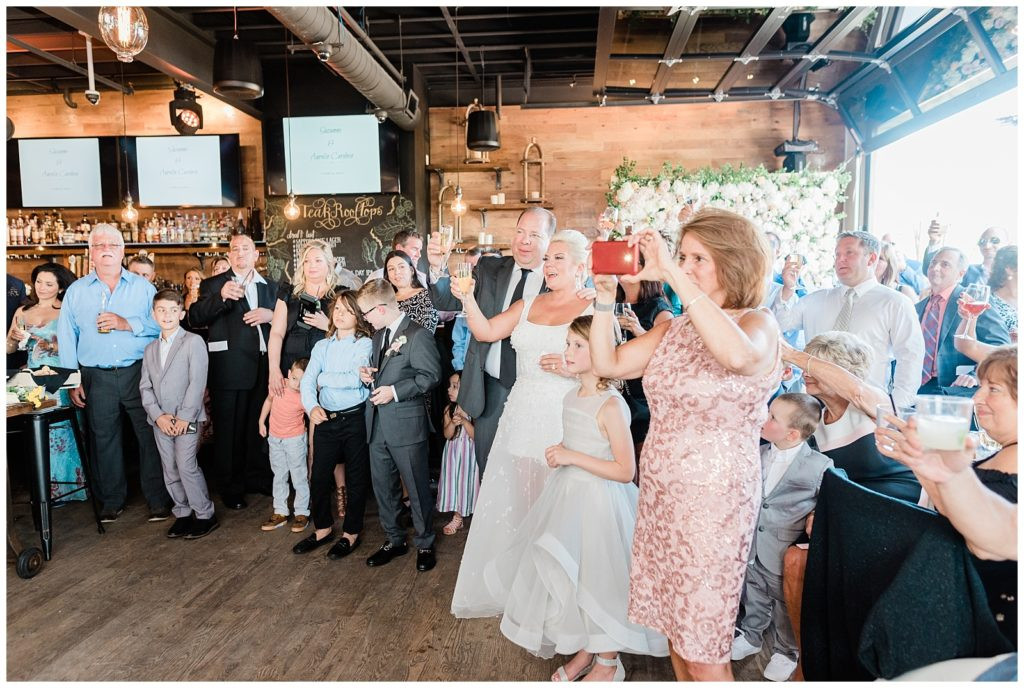 Bride and groom raising glasses for a toast at their wedding at Teak in Red Bank.
