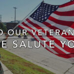 American flag waving in front of a bank on Veterans Day with the doors closed, symbolizing bank holidays